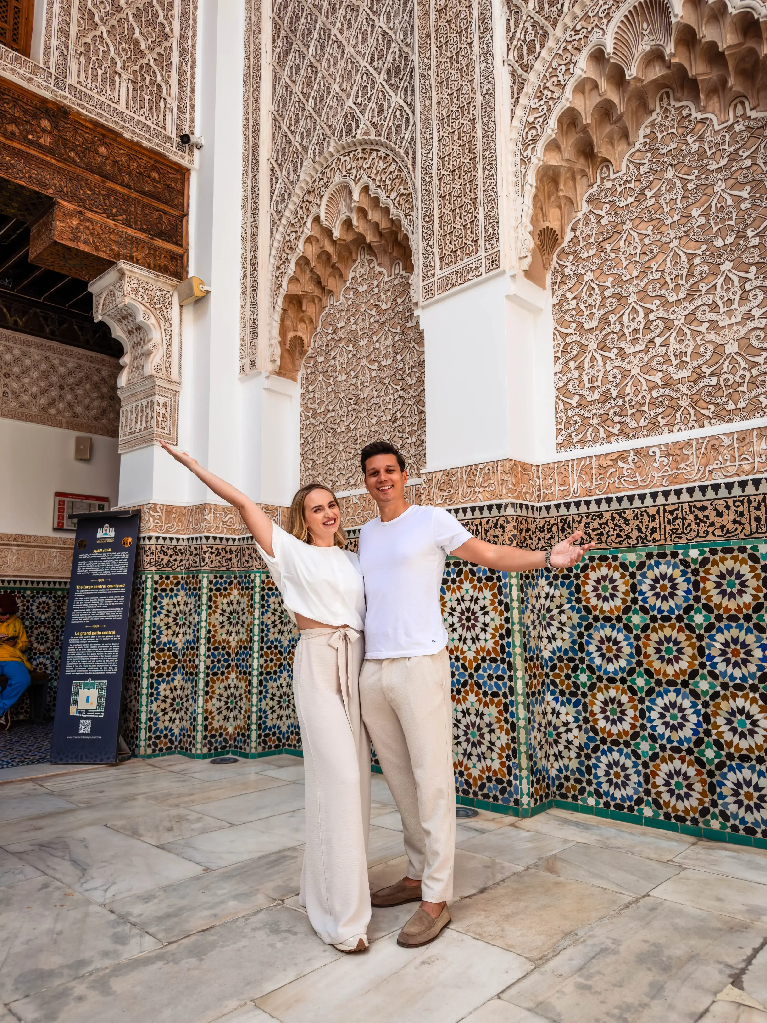 Andrei and Cristina posing in a traditional Moroccan riad with mosaic tiles