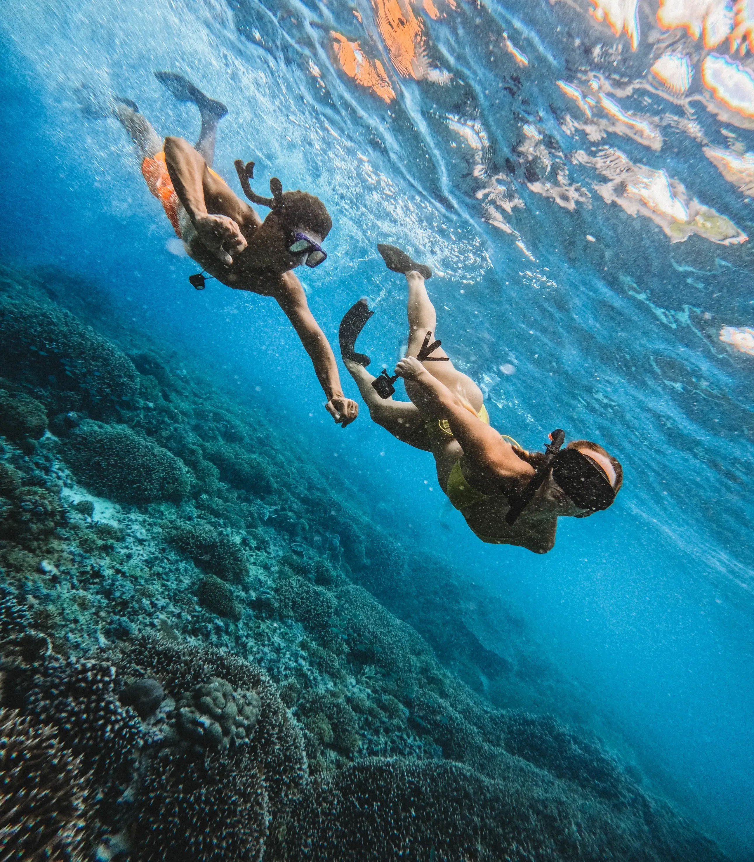 Andrei and Cristina snorkeling underwater above a coral reef